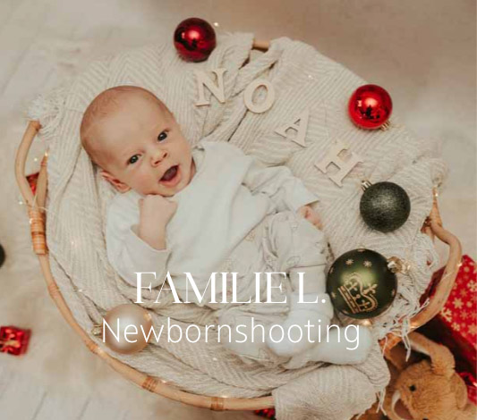 Baby lacht in die Kamera bei einem Newbornshooting für Weihnachtskarten