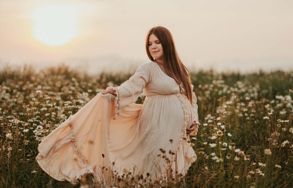 Babybauchshooting mit schwingendem Kleid bei Abendsonne am Kaiserstuhl