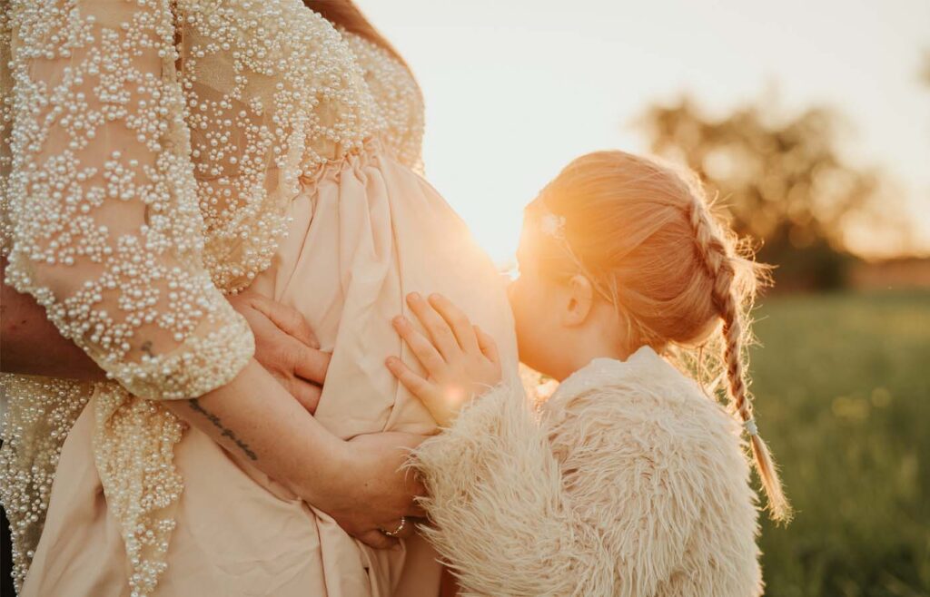 Babybauchshooting bei Sonnenuntergang mit Kind am Kaiserstuhl