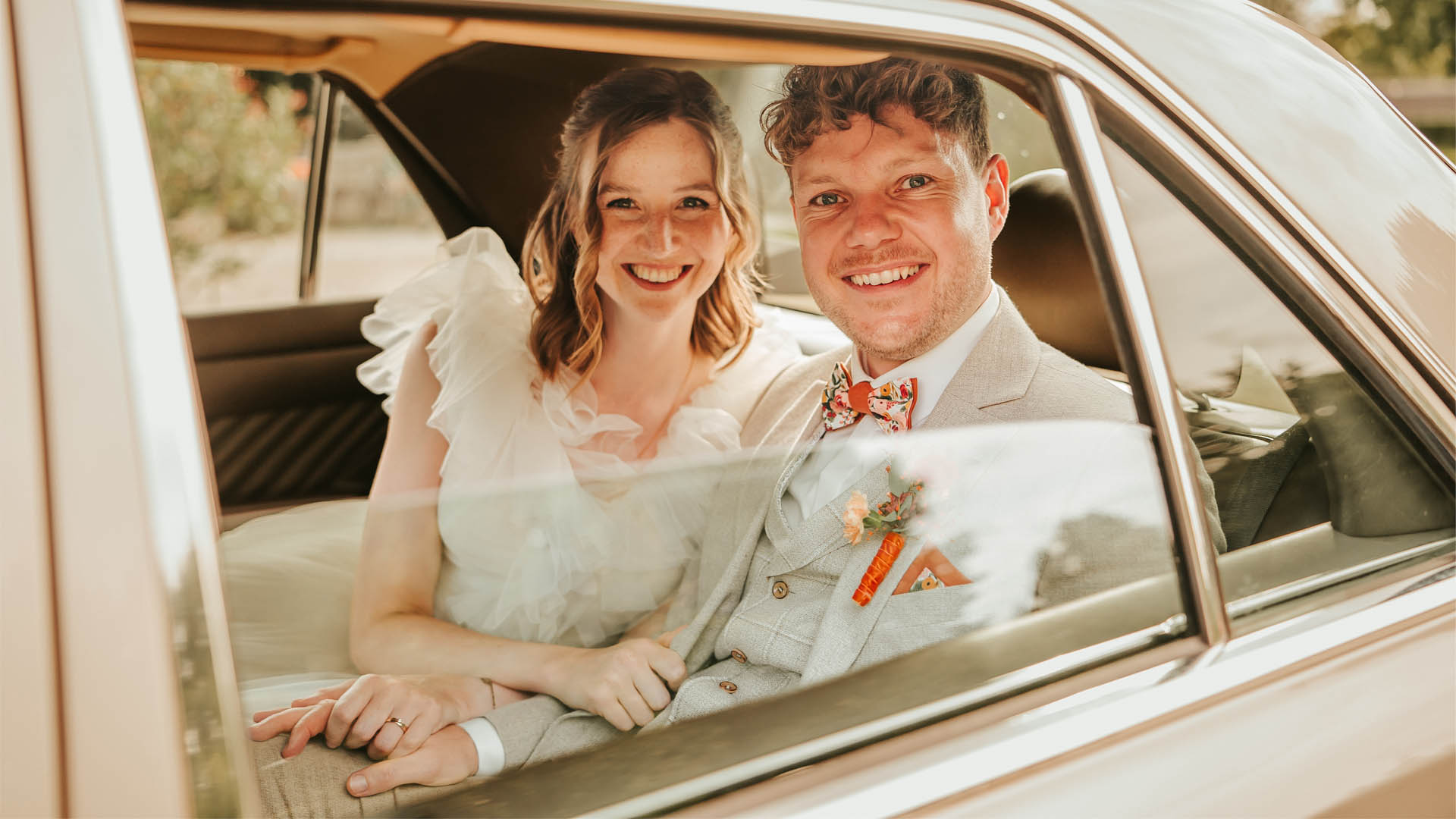 Brautpaar sitzt in Hochzeitsauto